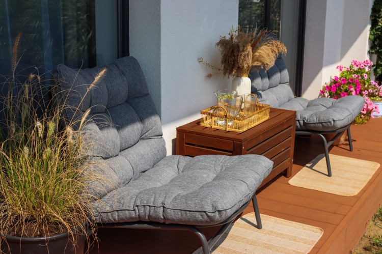 Fotel ogrodowy z grubą poduszką w szarym kolorze.